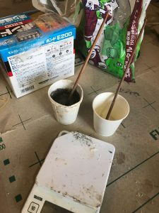 2液打ち継ぎボンドコニシE200と無収縮モルタルをデジタルスケール(計量器)で重さを測りながら調合