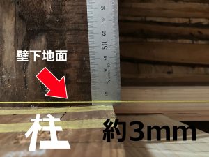 壁になる範囲で傾いた柱面の頂点から3mm内側へ張った水糸とそれを測る鋼製定規