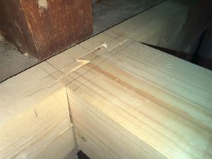 角欠損の既存梁へ添え抱かせ補強した45x105mmに大入れ蟻掛けメス口を掘り、新しく架ける補強梁105角に大入れ蟻掛けオス口を掘り接合テスト