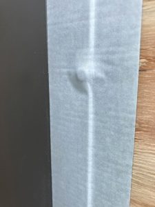 サッシ枠へ貼った両面防水テープに映った木ネジ