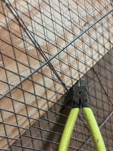 構造用合板の寸法をガイドにしてWラスをペンチで切って切断加工する