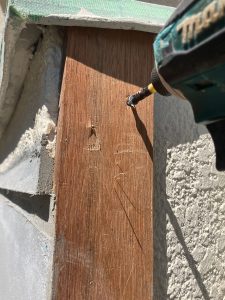 既存の出窓へ新しいモルタルを角を出しつつ垂直へ塗るために側面に当てた木を外す