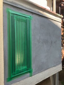塗り直したモルタル壁と取り替えた窓へは養生テープを貼り目地コーキングに備える