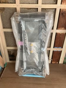 購入直後、緩衝材でくるまれたLIXIL 02607 サーモスL 縦すべり出し窓 W:300mm × H:770mm 一般複層ガラス カムラッチハンドル 樹脂アルミ複合タイプ(ハイブリッド窓)
