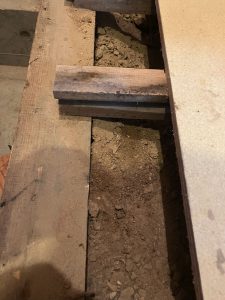 切断した合板からのぞく大量の土