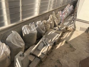 外に置いた土嚢袋に入った大量の土とコンクリートガラ