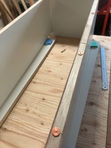 ダボ用マーカーを使用して穴あけ中の埋め込み型造り付けウォールキャビネット